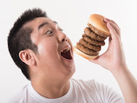 ハンバーガーを食べる男性